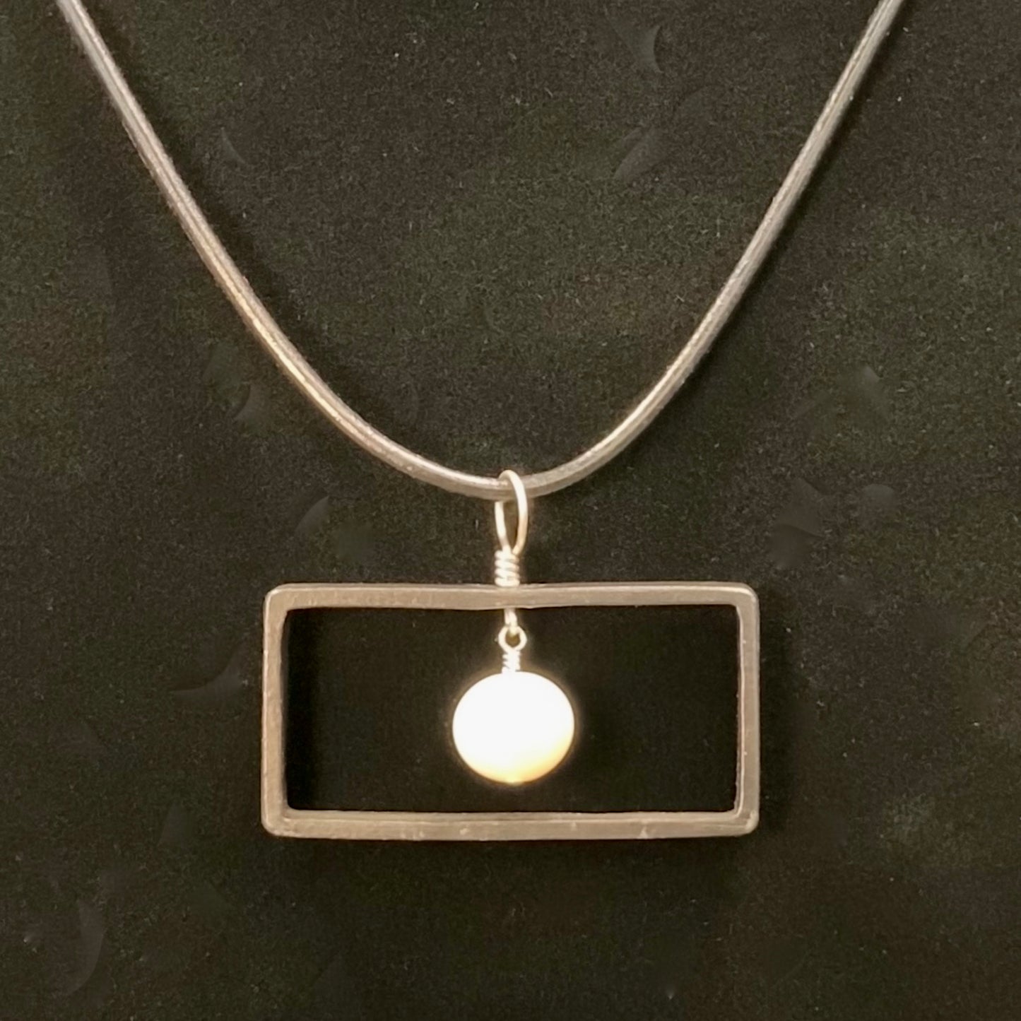 Blackened steel rectangle and pearl pendant