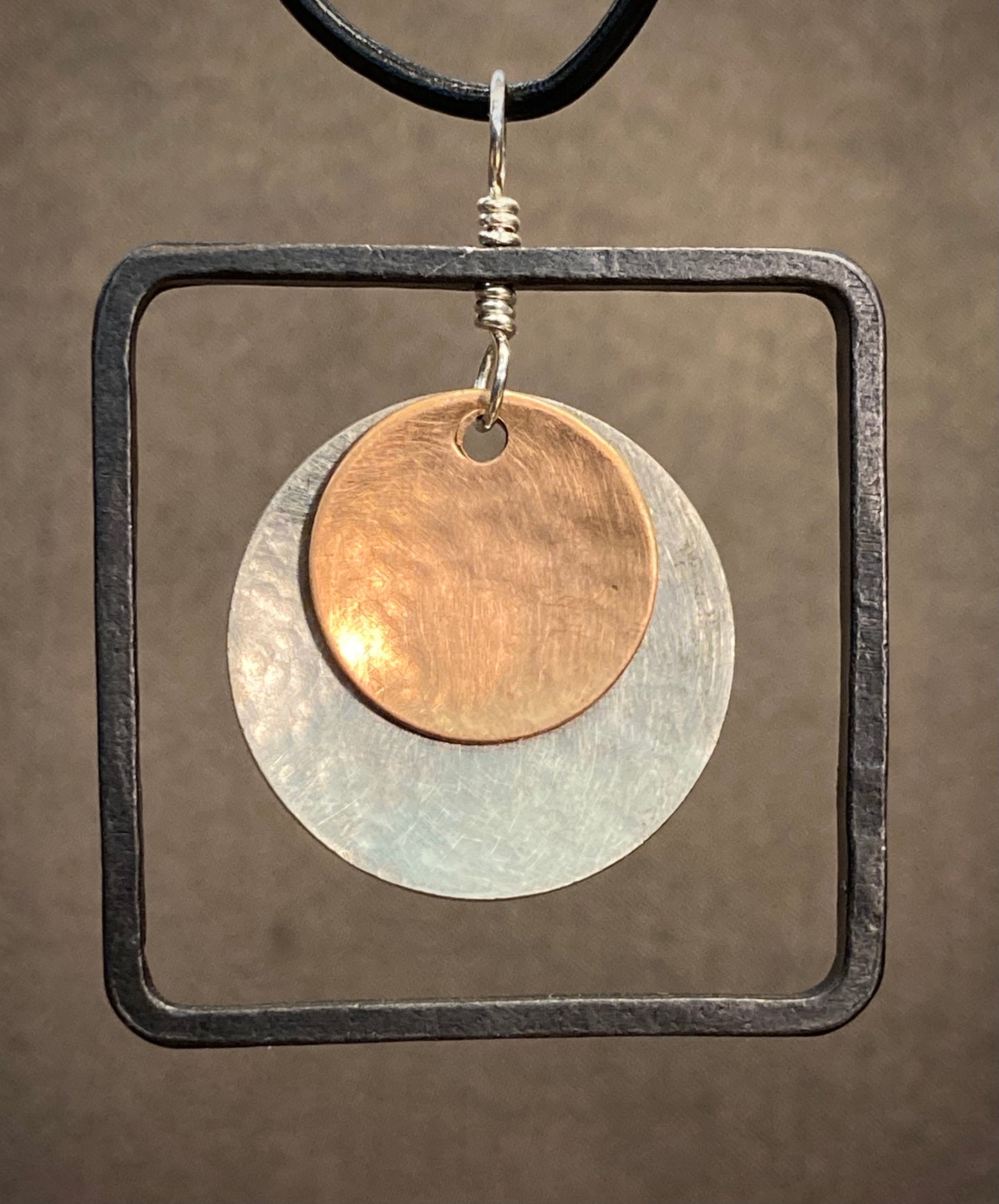Bronze, silver and blackened steel pendant